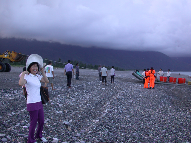 wife buying fish on beach